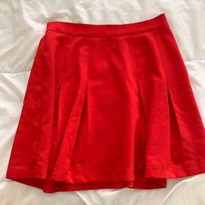 Red pleated above the knee skirt